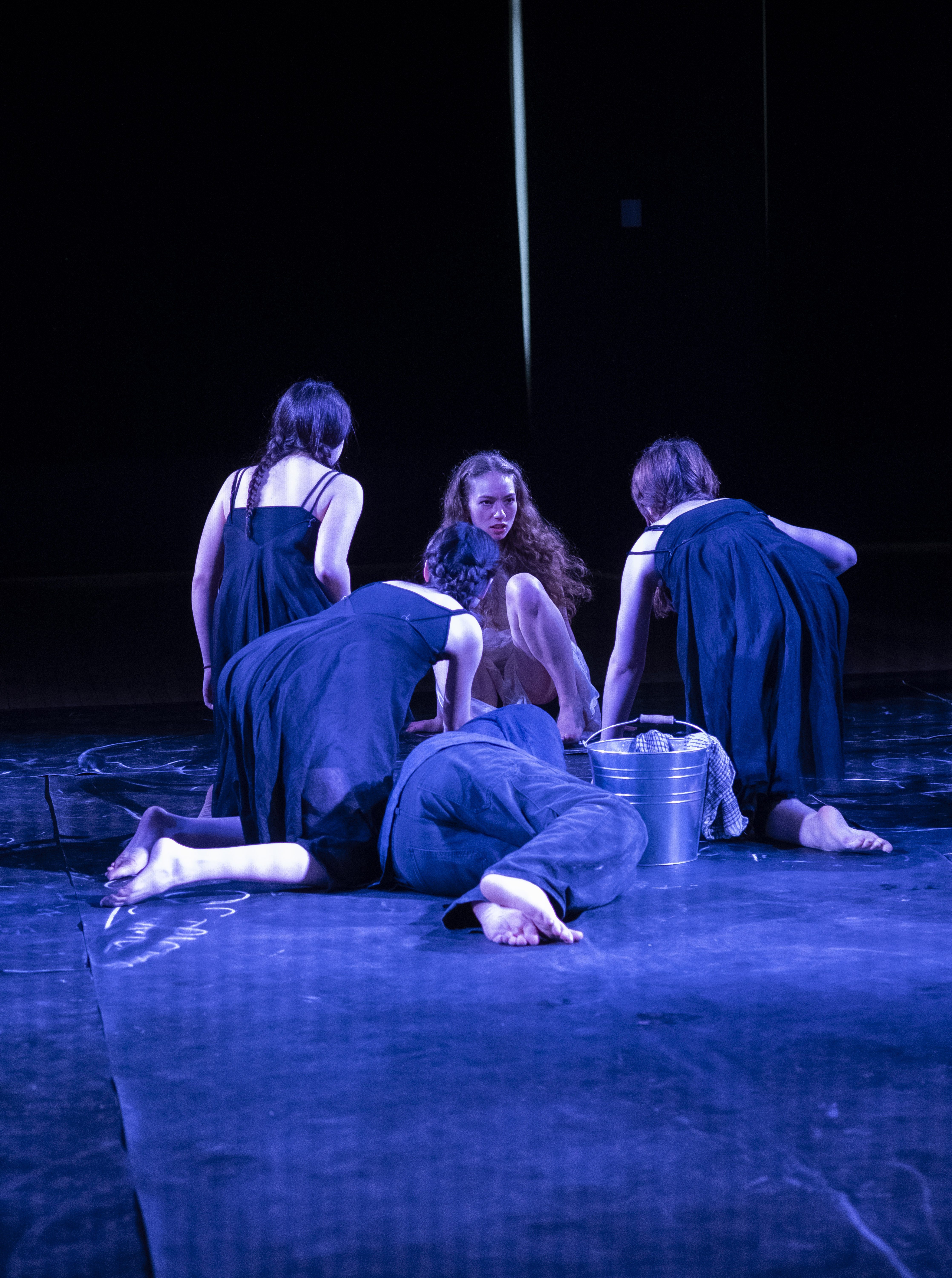 The Stones gathered around a bucket with a figure lying at their feet.