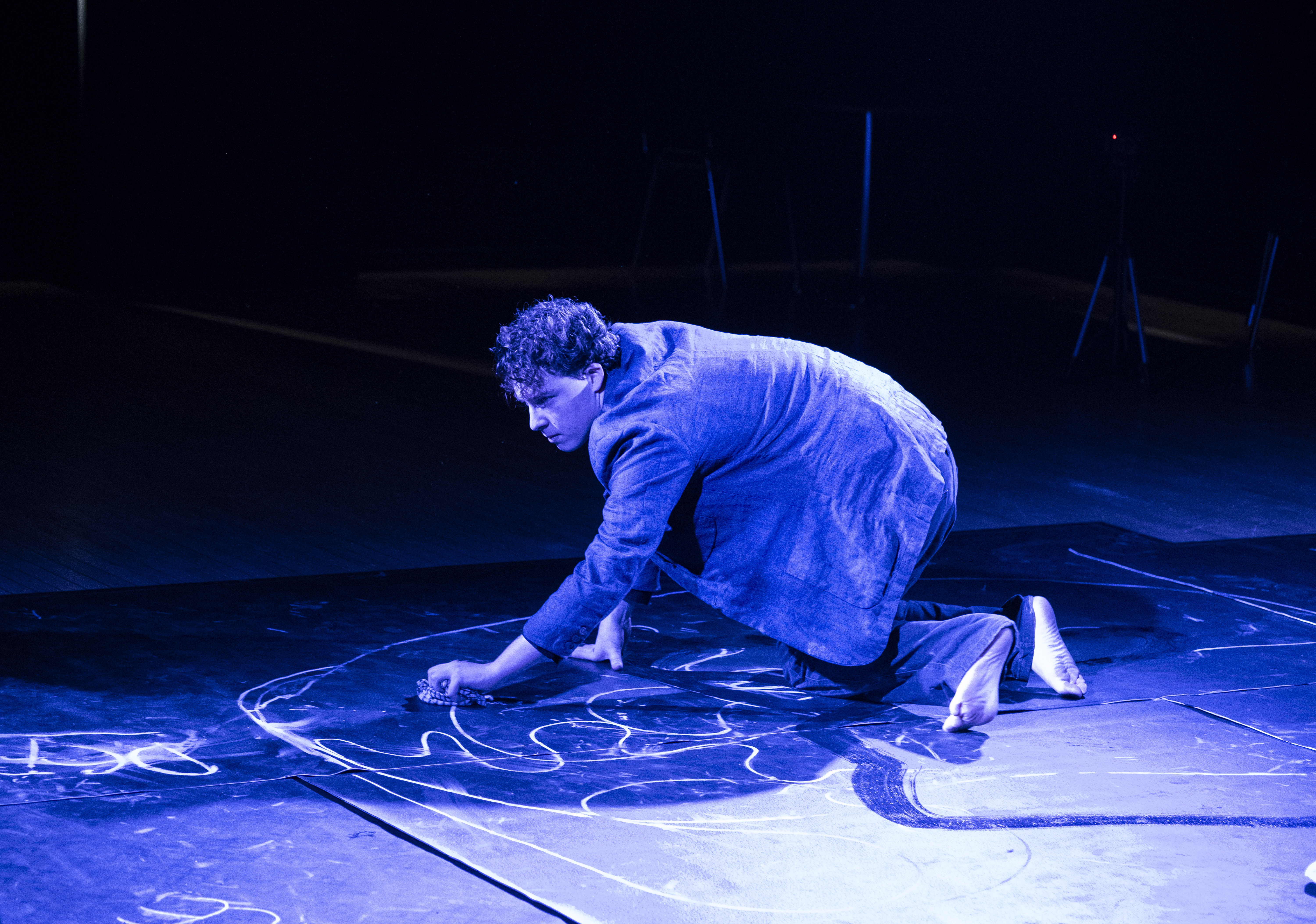 Eurydice's father crouched low, drawing on the stage floor in chalk.