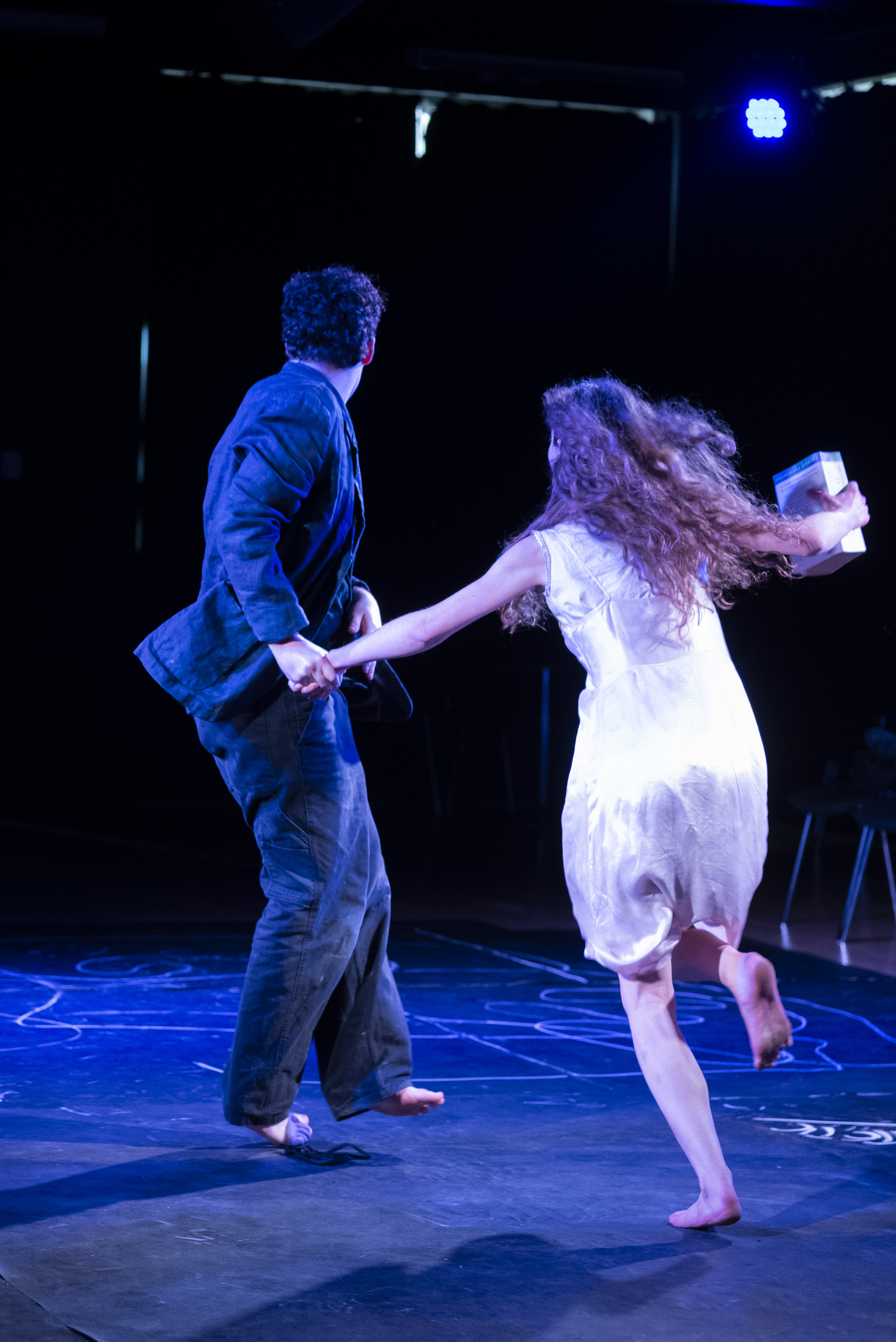 Eurydice running with a bucket, pulled back by Orpheus.
