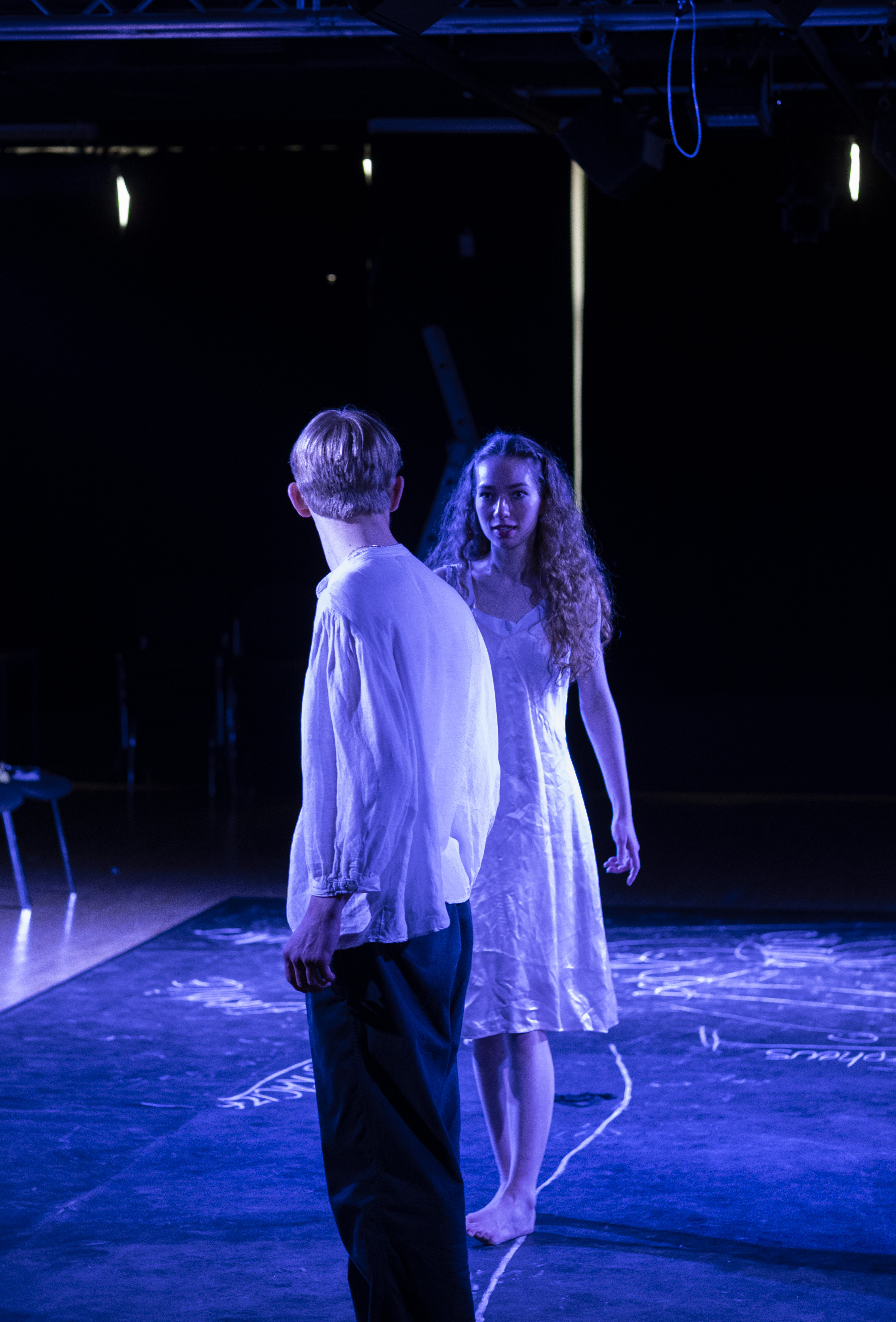 Eurydice and Orpheus walking side by side across the stage.